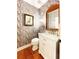 A powder room features wallpaper and marble countertop at 4150 Nature View Cir, Johns Island, SC 29455