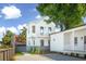 Charming two-story home with white siding, black trim, balcony, and modern landscaping at 42 Poinsett St # B, Charleston, SC 29403