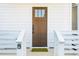 View of the home's beautiful brown front door, white siding, and black door hardware at 42 Poinsett St # B, Charleston, SC 29403