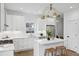 Bright, open kitchen featuring stainless steel appliances, white cabinets, a kitchen island, and modern lighting at 42 Poinsett St # B, Charleston, SC 29403