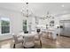 Open concept kitchen with stainless appliances, modern lighting, island with bar seating, and light hardwood floors at 42 Poinsett St # B, Charleston, SC 29403