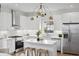 Well-lit kitchen featuring an island with barstools, stainless steel appliances, white cabinets and modern gold lighting at 42 Poinsett St # B, Charleston, SC 29403