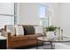 Bright living room with a stylish leather sofa, accent pillows, modern coffee table, and ample natural light at 42 Poinsett St # B, Charleston, SC 29403