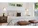 Bright and airy main bedroom with a plush bed, stylish lighting, and large windows offering views of the outdoors at 42 Poinsett St # B, Charleston, SC 29403