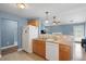 Efficient kitchen with wood cabinets, white appliances, and an open layout flowing into the living area at 432 Equinox Cir, Ladson, SC 29456