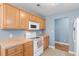 Functional kitchen featuring wooden cabinets, white appliances, and tiled floors, offering an efficient workspace at 432 Equinox Cir, Ladson, SC 29456