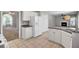 Open-concept kitchen featuring stainless appliances, tile flooring, white cabinetry, and a view of the fireplace at 434 Antebellum Ln, Mount Pleasant, SC 29464