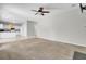 Expansive living room blending carpet and tile, connecting seamlessly to the kitchen, complete with a ceiling fan at 434 Antebellum Ln, Mount Pleasant, SC 29464