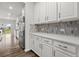Bright kitchen featuring white cabinets, quartz countertops, tile backsplash, and stainless steel refrigerator at 514 Purple Finch Rd, Summerville, SC 29486