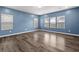 Bright living room featuring blue walls and large windows at 514 Purple Finch Rd, Summerville, SC 29486