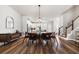A modern dining room featuring a stylish wood table, pendant lighting, and luxury vinyl plank flooring at 582 Mclernon Trce, Johns Island, SC 29455