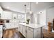 A bright kitchen features a quartz counter island with bar stool seating, white cabinets and stainless appliances at 582 Mclernon Trce, Johns Island, SC 29455