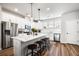 The open-concept kitchen offers white cabinets, stainless appliances, quartz countertops and bar stool seating at 582 Mclernon Trce, Johns Island, SC 29455