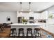 The open-concept kitchen offers white cabinets, stainless appliances, quartz countertops and bar stool seating at 582 Mclernon Trce, Johns Island, SC 29455