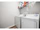 Functional laundry room features a washer, dryer, and shelving for supplies at 582 Mclernon Trce, Johns Island, SC 29455