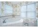 Bathroom features a corner tub, white tile and floral wallpaper at 5847 Back Bay Dr, Isle of Palms, SC 29451