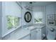 Bright bathroom features white cabinets, and a large mirror at 5847 Back Bay Dr, Isle of Palms, SC 29451