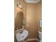 Chic bathroom features a pedestal sink, decorative mirror, unique wallpaper, and hardwood floors at 5847 Back Bay Dr, Isle of Palms, SC 29451