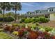 Clubhouse exterior surrounded by colorful flower beds, mature trees, and well-maintained landscaping at 5847 Back Bay Dr, Isle of Palms, SC 29451