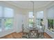 Bright dining area with glass table, four chairs, and multiple windows providing natural light at 5847 Back Bay Dr, Isle of Palms, SC 29451