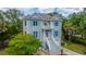 Two-story home featuring light grey siding, blue shutters, front yard with trees and manicured landscaping at 5847 Back Bay Dr, Isle of Palms, SC 29451