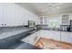 Bright kitchen with white cabinets, dark countertops, stainless appliances, and hardwood floors at 5847 Back Bay Dr, Isle of Palms, SC 29451