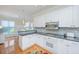 Well-lit kitchen featuring white cabinetry, modern appliances, and access to an adjacent dining area at 5847 Back Bay Dr, Isle of Palms, SC 29451