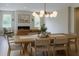 Elegant dining room with modern lighting fixture, wood table, and a view of the fireplace at 69 Red Bluff St, Summerville, SC 29483