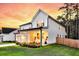 Charming two-story home with white siding, a covered porch, and lush green lawn at sunset at 69 Red Bluff St, Summerville, SC 29483