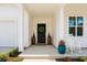 Inviting front porch with black door, decorative wreath, potted plants, and rocking chair at 69 Red Bluff St, Summerville, SC 29483