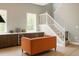 Stylish living room featuring hardwood floors, staircase, built in bar, and orange sofa at 69 Red Bluff St, Summerville, SC 29483