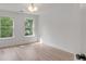 Bright bedroom with large windows, hardwood floors, white walls and a modern light fixture at 7053 Schooner St, Daniel Island, SC 29492