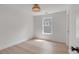 Well lit bedroom featuring hardwood floors, white walls and trim, modern light fixture, and a window at 7053 Schooner St, Daniel Island, SC 29492
