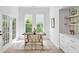 Elegant dining area with wood floors, stylish chairs, modern table, built-in shelving and lovely natural light at 7053 Schooner St, Daniel Island, SC 29492