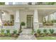 Inviting front porch with decorative plants, hanging flower baskets, and space for relaxing at 7053 Schooner St, Daniel Island, SC 29492