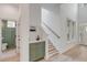 Bright hallway featuring a staircase, hardwood floors, a bar, and access to a stylish powder room at 7053 Schooner St, Daniel Island, SC 29492