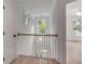 Upstairs hallway with white walls, light wood floors, modern lighting, and a view of the outdoors at 7053 Schooner St, Daniel Island, SC 29492
