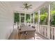 Charming screened porch with dining table set, ceiling fan, and great views of the lush backyard at 7053 Schooner St, Daniel Island, SC 29492