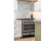Close-up of the kitchen gas range with stainless steel oven and white subway tile backsplash at 7053 Schooner St, Daniel Island, SC 29492