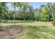 Expansive grassy backyard surrounded by mature trees and privacy fence at 7878 Gull Bay Dr, Awendaw, SC 29429