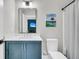 Well-lit bathroom with blue vanity, white countertop, and a shower with a striped curtain at 7878 Gull Bay Dr, Awendaw, SC 29429