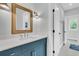 Modern bathroom with a blue vanity, white countertop, and a gold-framed mirror at 7878 Gull Bay Dr, Awendaw, SC 29429