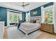 Cozy bedroom with teal walls, white furniture, large windows, and natural light at 7878 Gull Bay Dr, Awendaw, SC 29429
