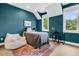 Stylish bedroom with blue walls, a comfortable bed, and a desk area with a sleek black chair at 7878 Gull Bay Dr, Awendaw, SC 29429