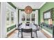 Elegant dining room with green walls, large windows, and a stylish chandelier above a long table at 7878 Gull Bay Dr, Awendaw, SC 29429