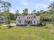 Stunning white home featuring a charming front porch and a lush green lawn at 7878 Gull Bay Dr, Awendaw, SC 29429