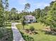 Picturesque home with a long driveway, lush landscaping, and a charming front porch at 7878 Gull Bay Dr, Awendaw, SC 29429