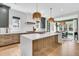 Bright kitchen featuring a large island, custom cabinetry, and pendant lighting at 7878 Gull Bay Dr, Awendaw, SC 29429