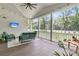 Inviting screened porch with comfortable seating, string lights, and views of the wooded yard at 7878 Gull Bay Dr, Awendaw, SC 29429