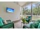 Relaxing screened porch with cozy armchairs, a decorative rug, and lush greenery at 7878 Gull Bay Dr, Awendaw, SC 29429